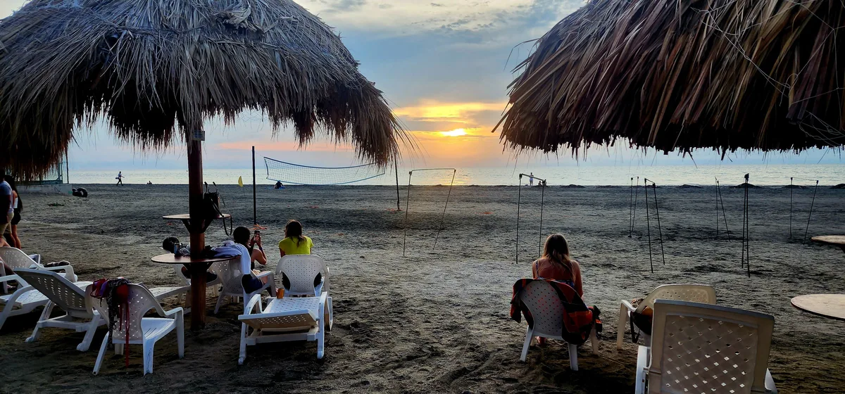 Club de Playa al atardecer con cancha de voleibol y palmeras