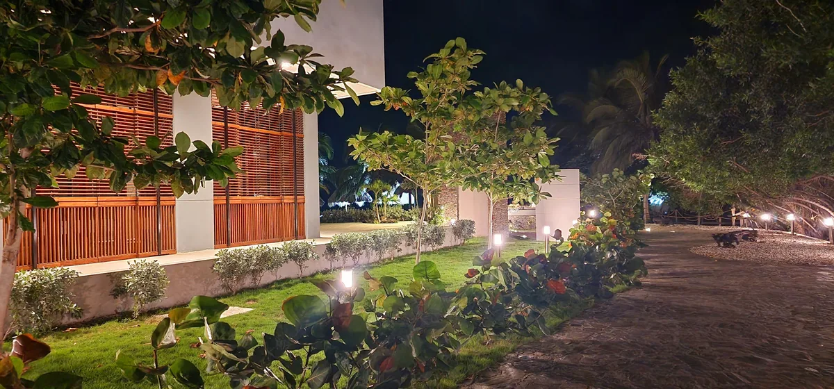 Jardín exterior iluminado del condominio Reserva del Mar al anochecer